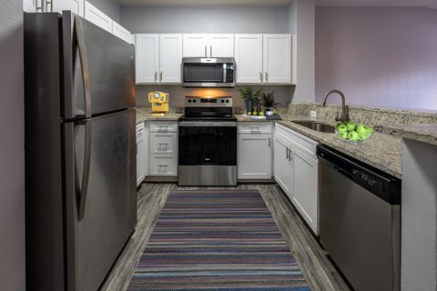 a kitchen with stainless steel appliances and granite counter tops